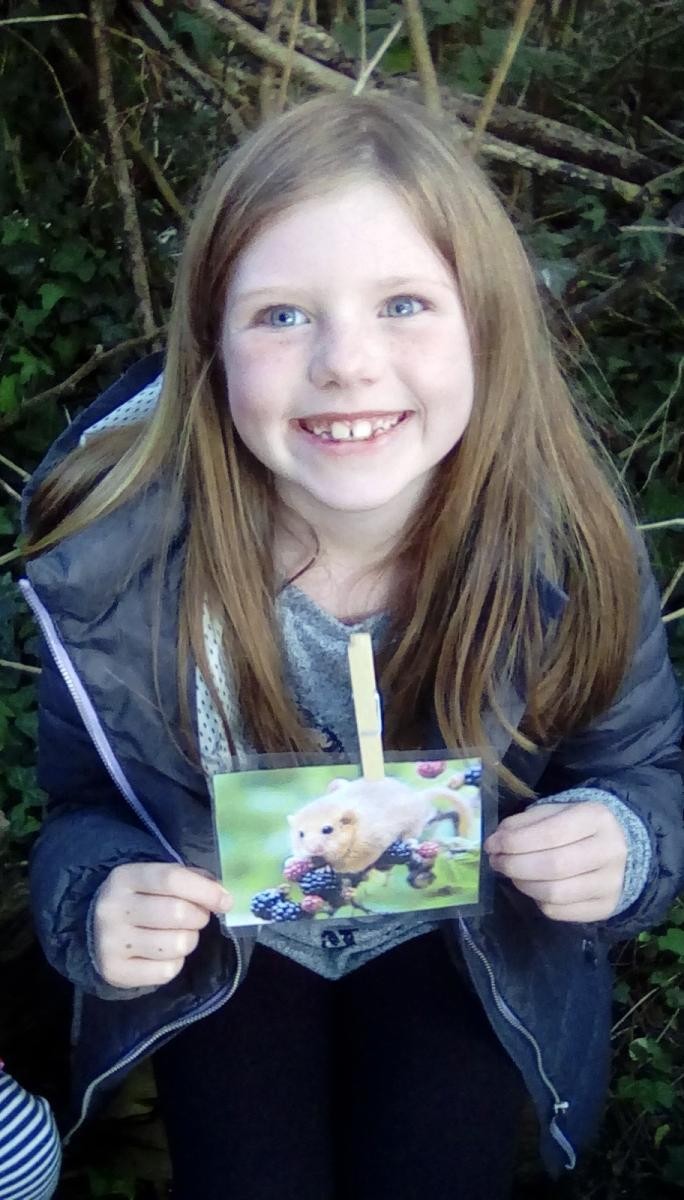 Smiling child holding a photo of a door mouse